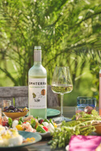 bottle of Bonterra Sauvignon Blanc set on table with plates of salads and olives