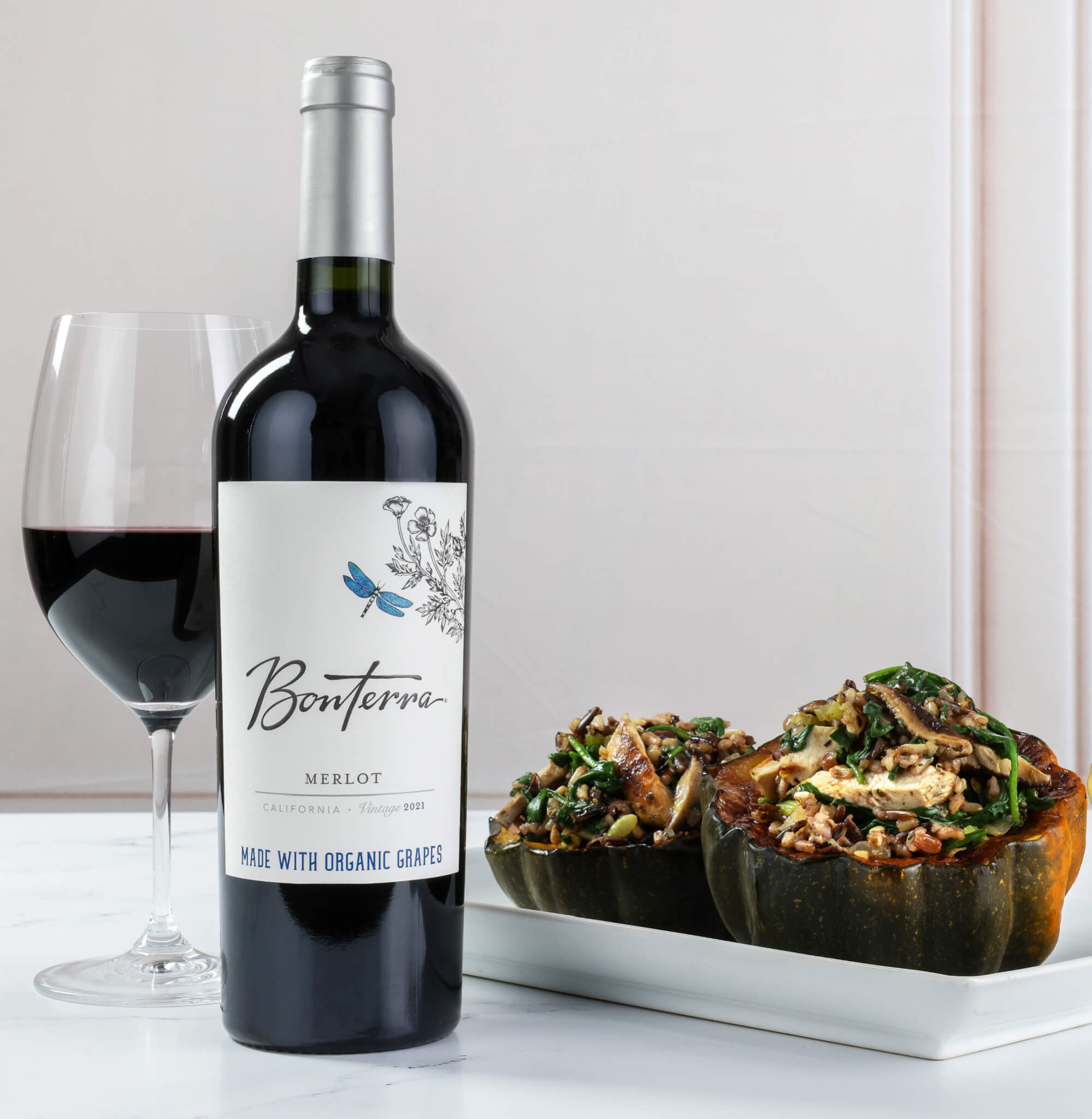 Bottle shot of 2021 Bonterra Merlot red wine, with stuffed squash dish on the side