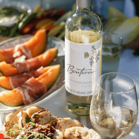 Bottle shot of Bonterra Sauvignon Blanc with several dishes in the background