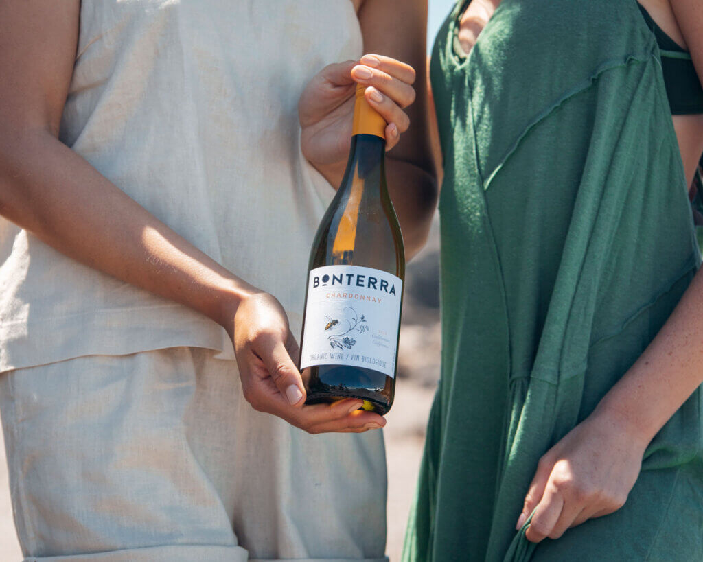 woman holding a bottle of white wine