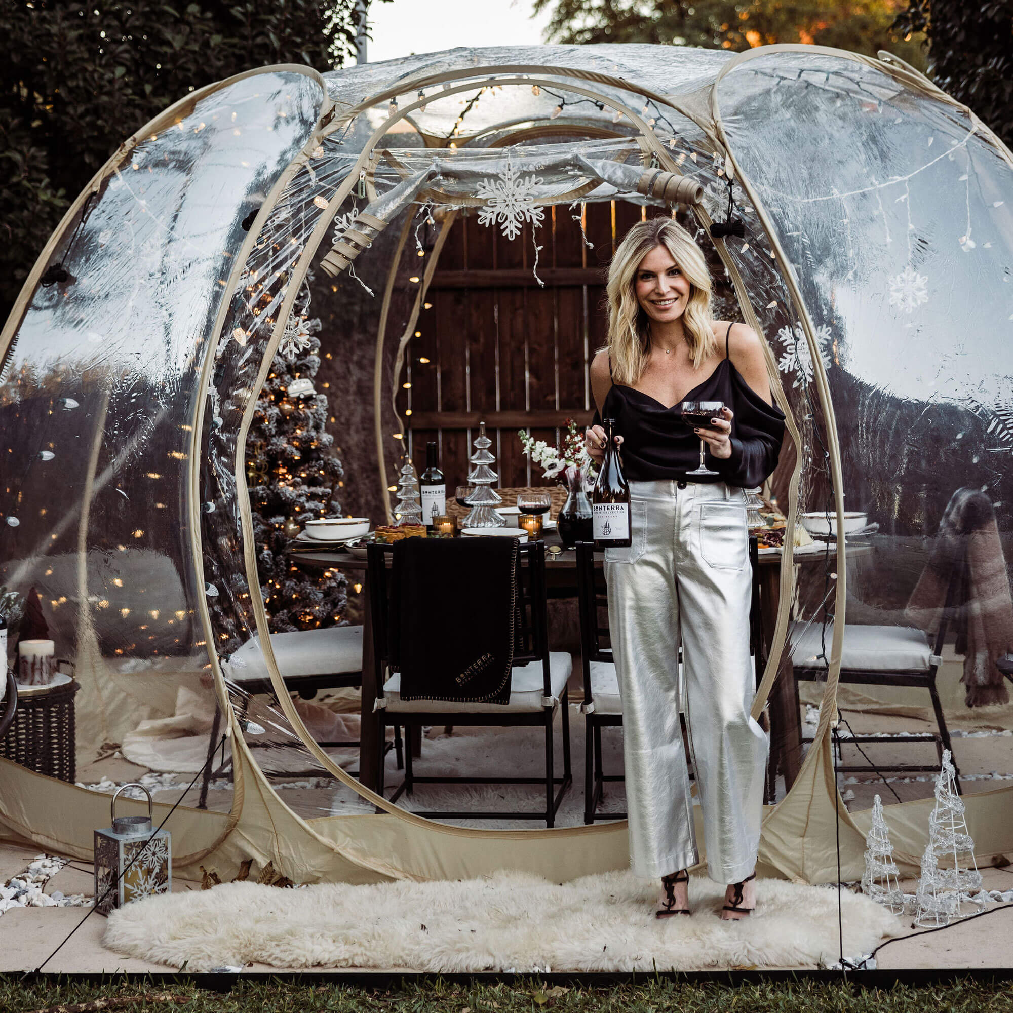 woman standing in front of a wintery outdoor dinner party table setting